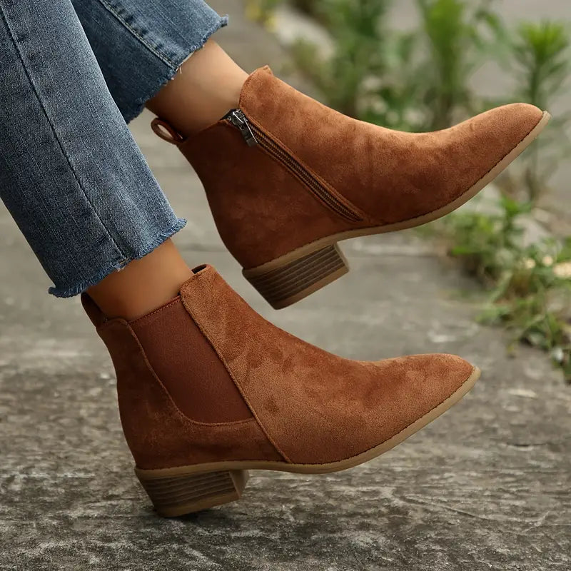 Brown suede pointed-toe Chelsea boots for women worn with cropped jeans, showing the side zip and block heel