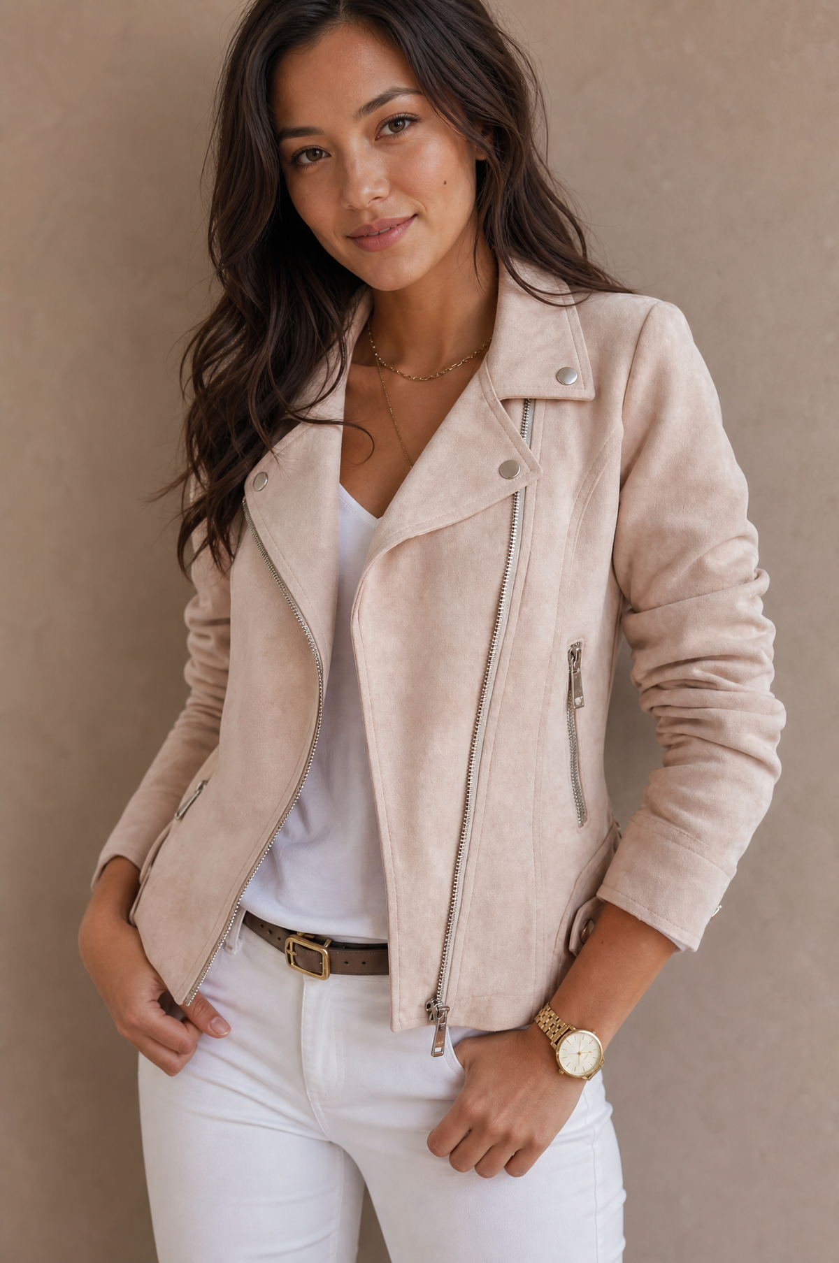 A woman wearing a beige suede jacket with an asymmetrical zip, notched lapel, and hip-length fit