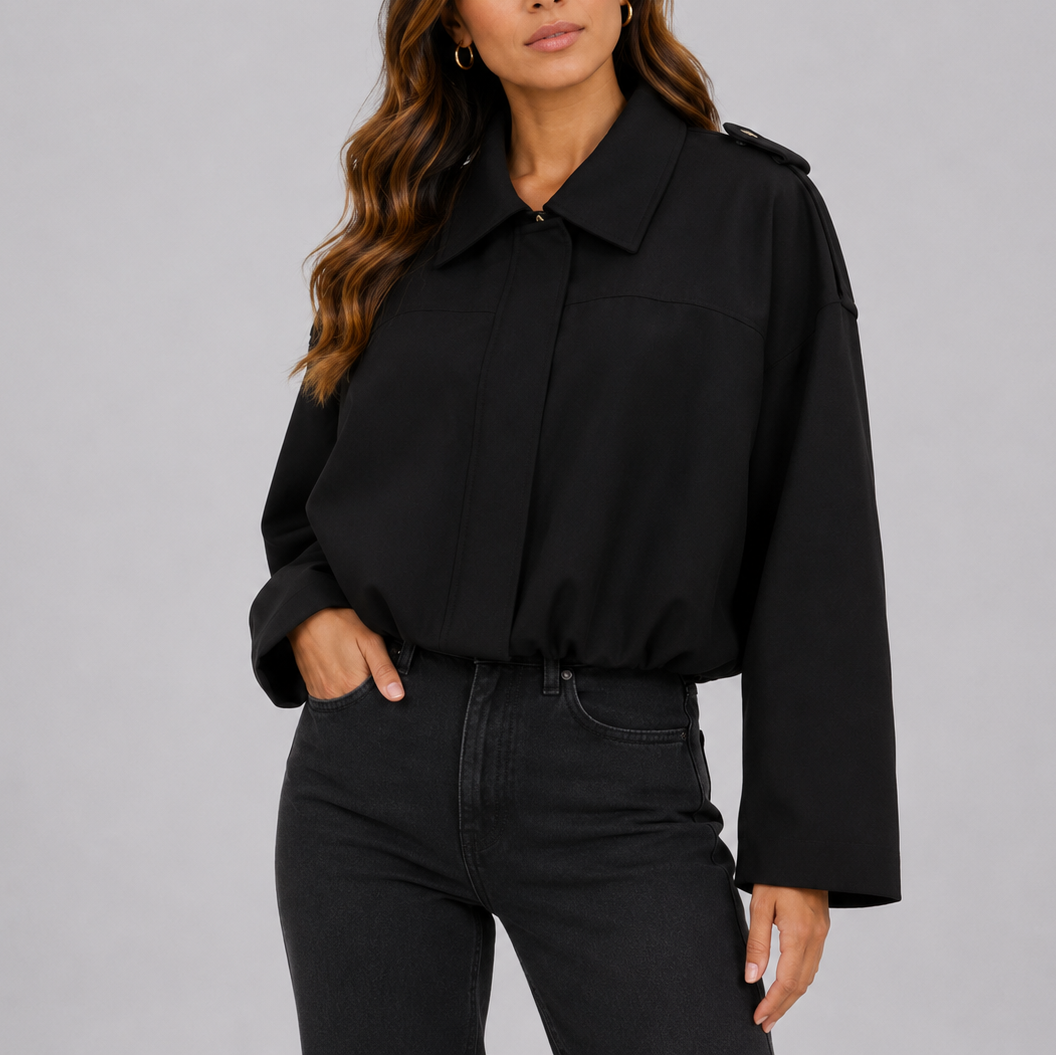 A woman wearing a black suede jacket with an oversized fit, bomber style, and wide sleeves