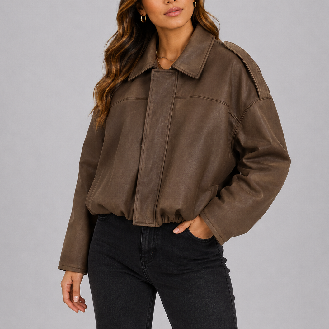 A woman wearing a brown suede jacket with an oversized fit, bomber style, and wide sleeves