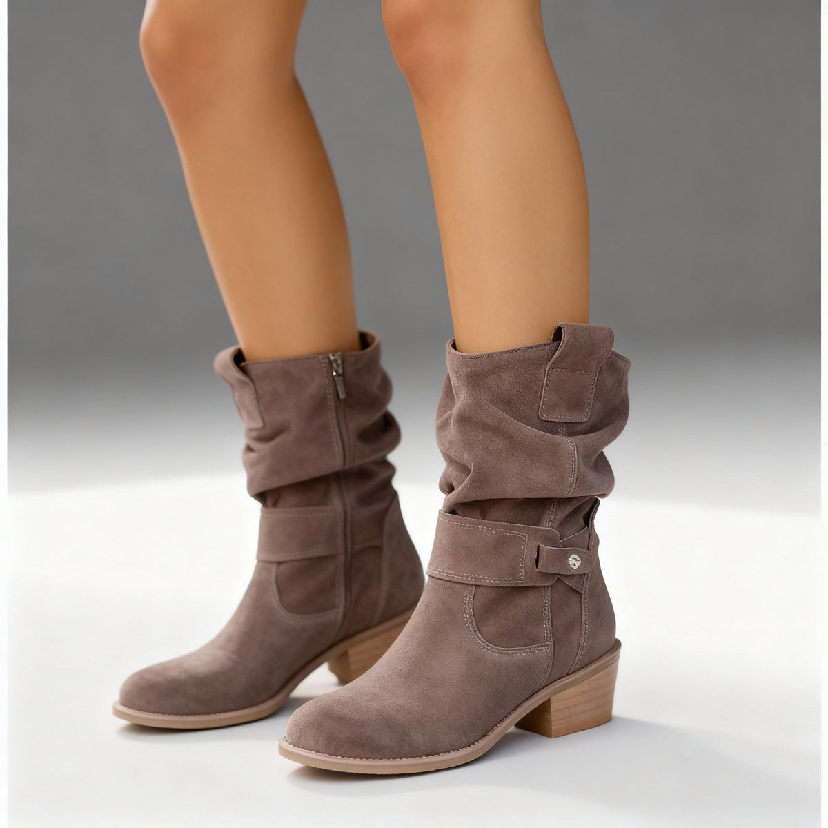 Taupe suede slouchy ankle boots with low block heels and buckle details.