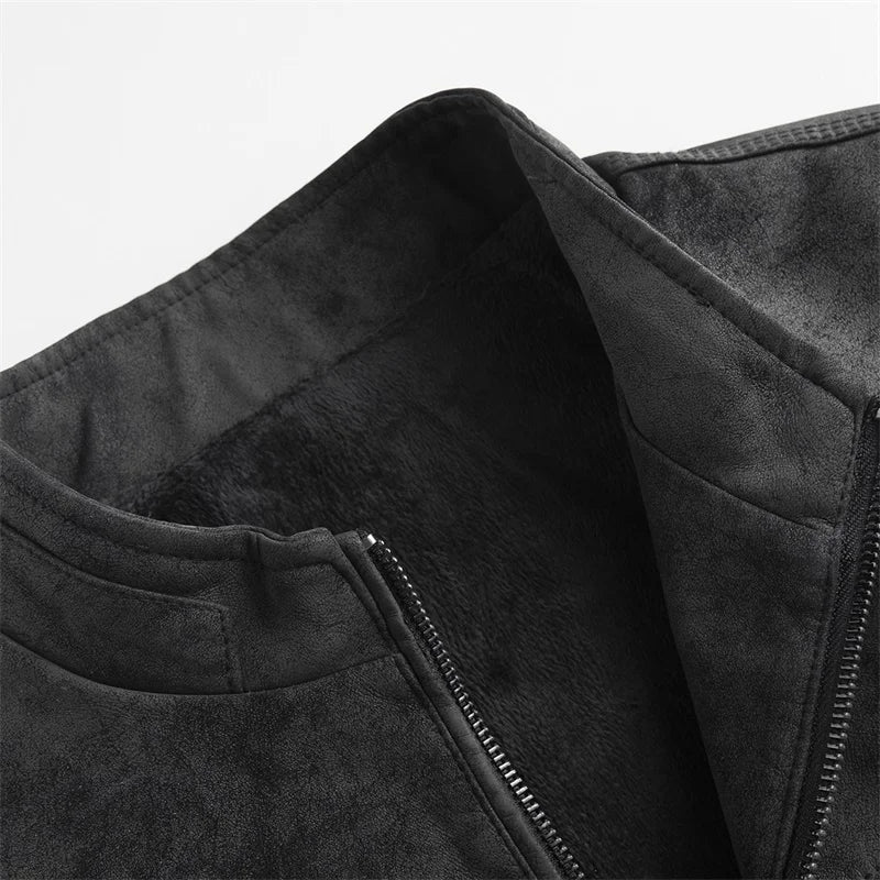 Close-up of a black distressed suede moto jacket showing the textured finish and stitched panel detail