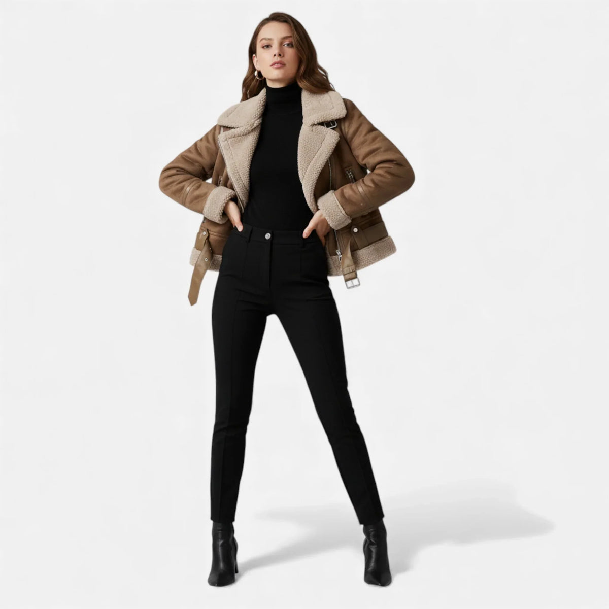 A woman wearing a brown suede shearling aviator jacket with a belted waist, asymmetric zip front, and plush shearling collar, front view