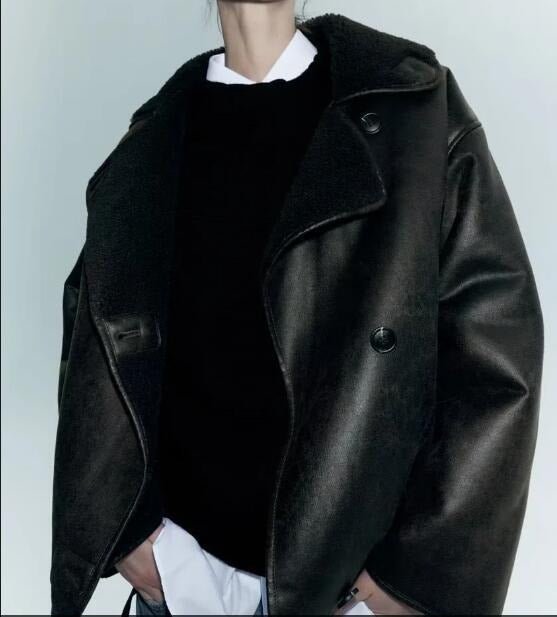 Black suede shearling jacket worn by a women with a boxy fit, plush lining, and aviator style