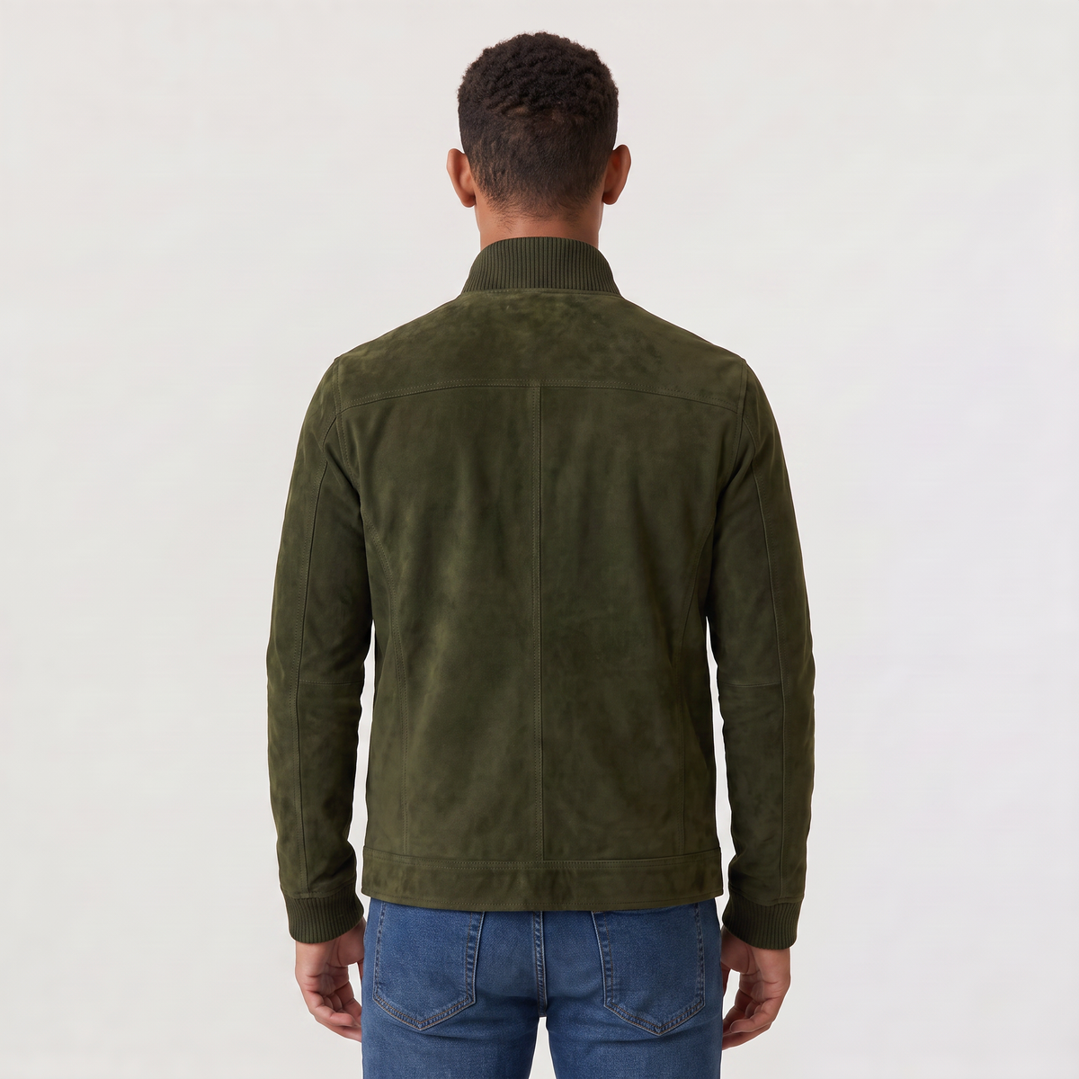 A man wearing an olive green suede trucker jacket with a button front, stand collar, and chest pockets, back view