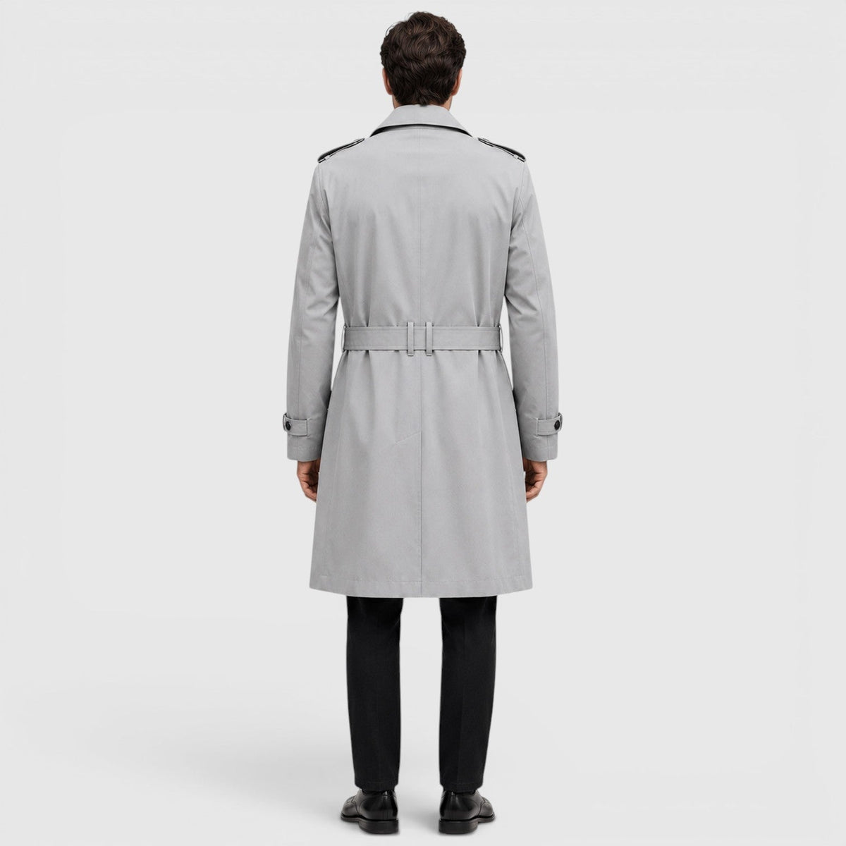 A man wearing a light gray tailored double-breasted trench coat with an adjustable belt, shown from the back
