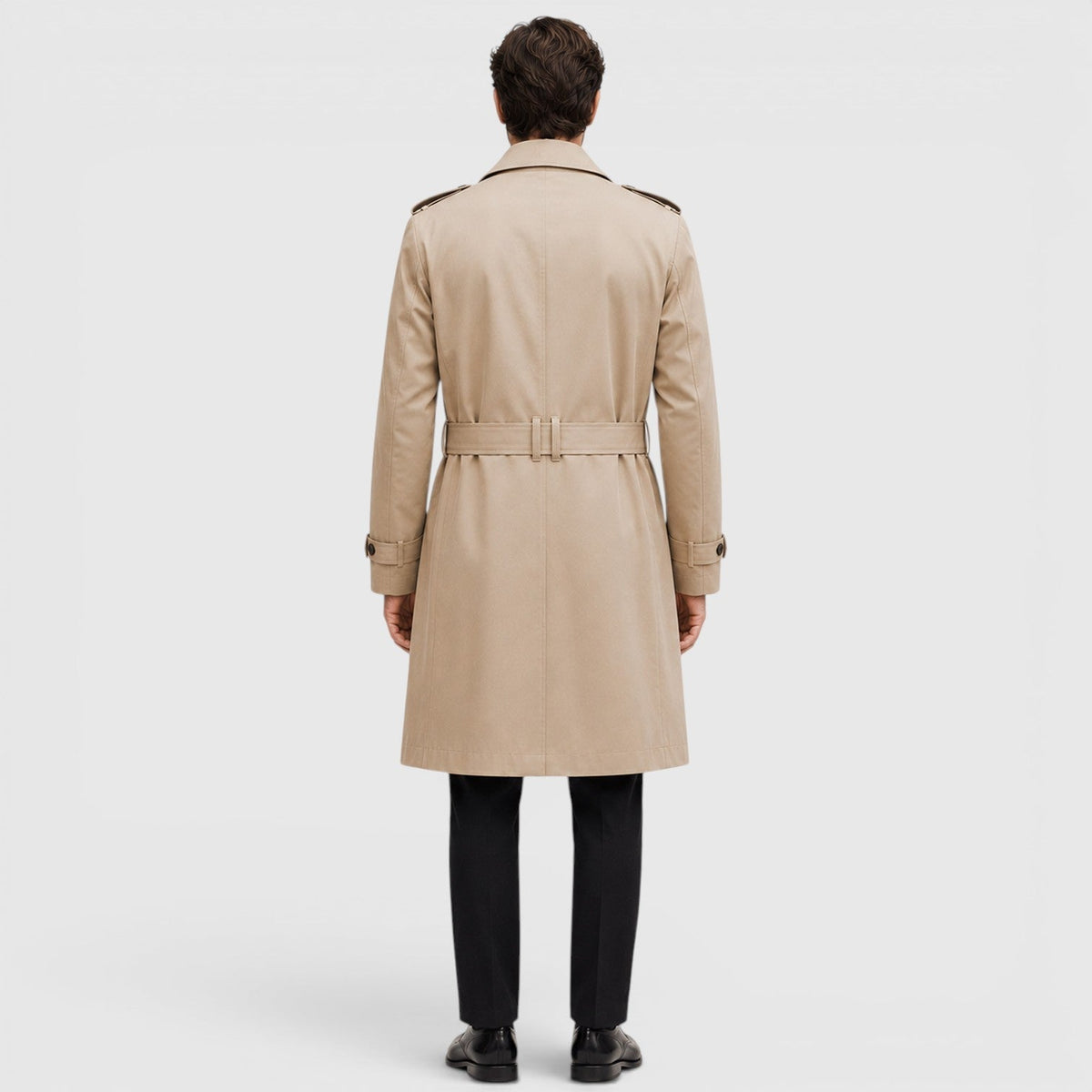A man wearing a beige tailored double-breasted trench coat with an adjustable belt, shown from the back