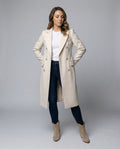 A woman wearing a white wool midi overcoat with a double-breasted front and notched lapels