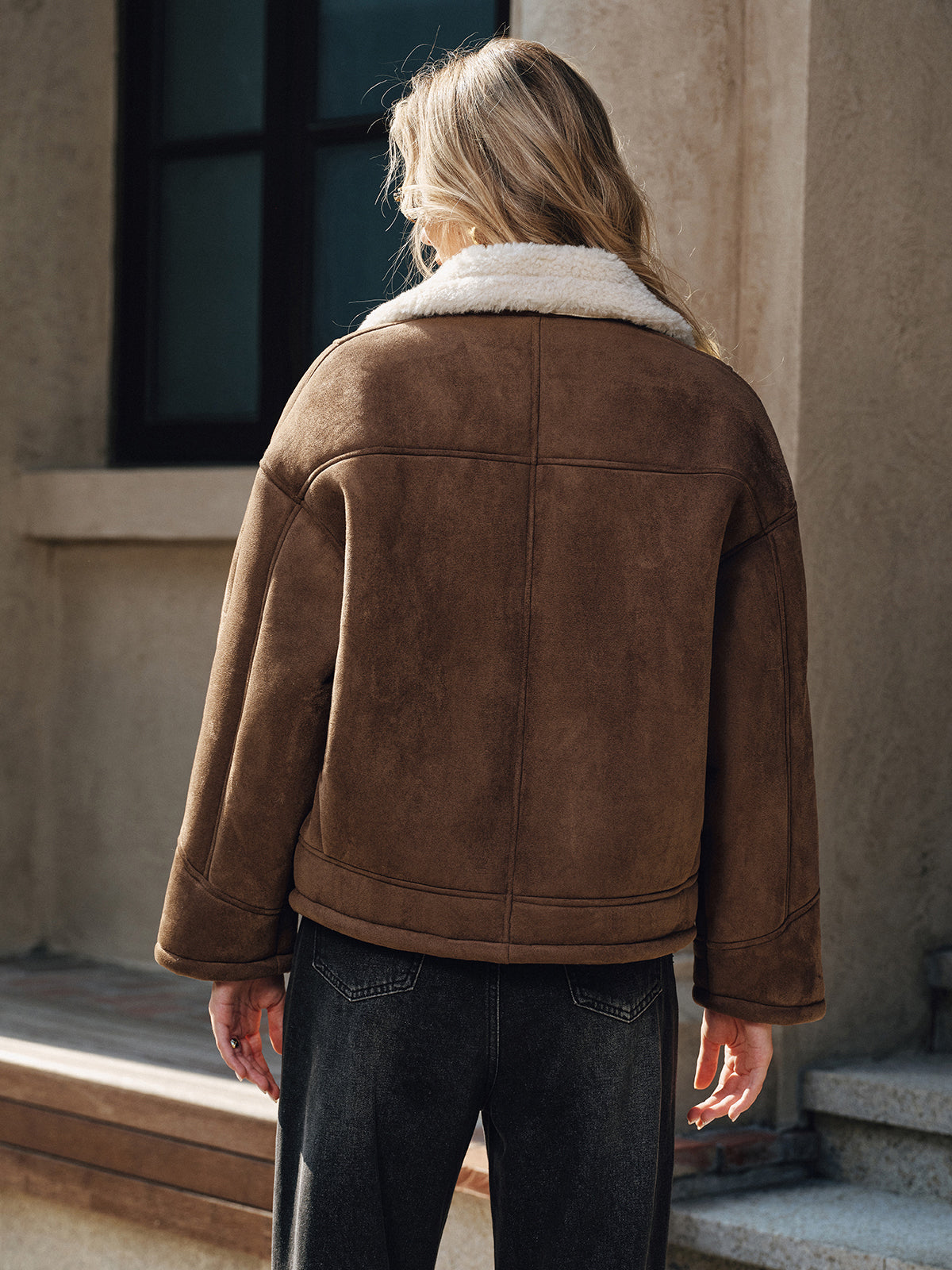 Brown thickened wool shearling jacket worn by a female model, back view showing the boxy fit and plush lining