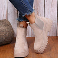 Beige vegan leather platform Chelsea ankle boots for women with cleated lug sole, worn with cropped jeans