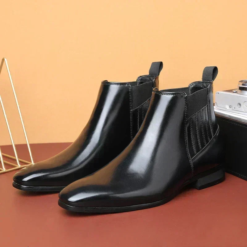 Pair of dark brown vegan leather pointed-toe Chelsea boots for men with elastic side panels and rear pull tabs