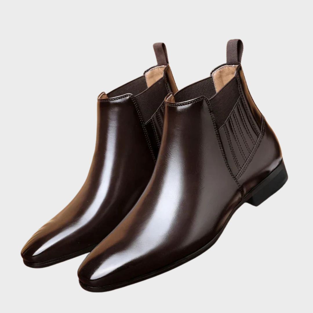 Dark brown vegan leather Chelsea boots for men with low stacked heel, styled on a terracotta surface