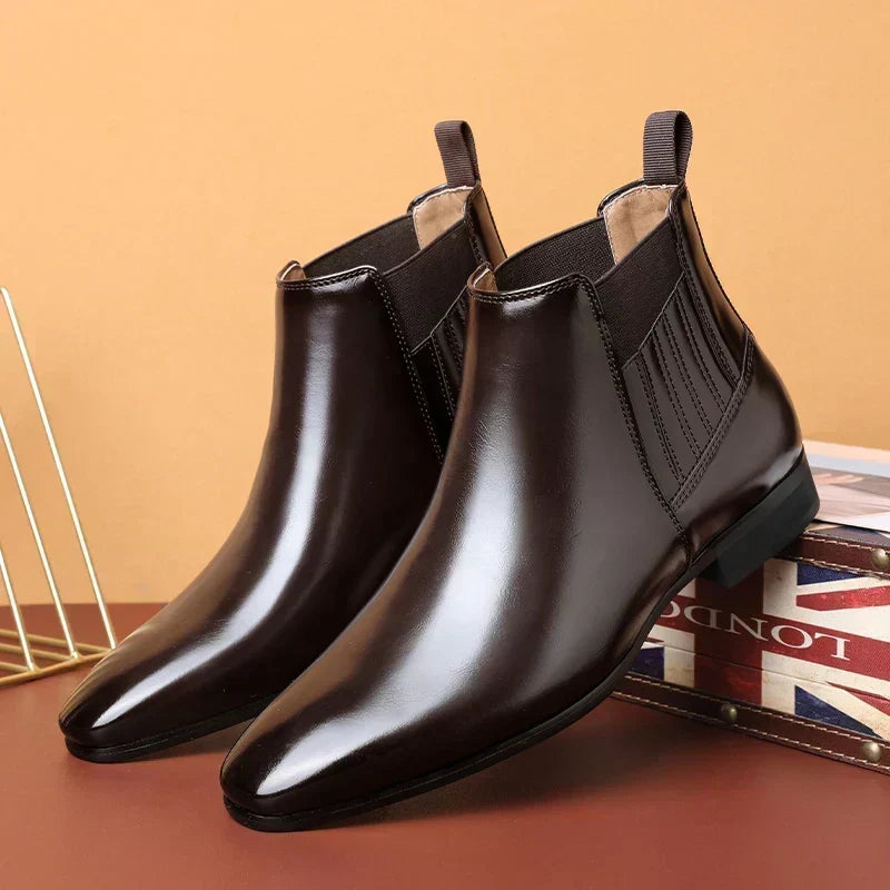 Dark brown vegan leather Chelsea boots for men with pointed toe and low stacked heel, on a plain background