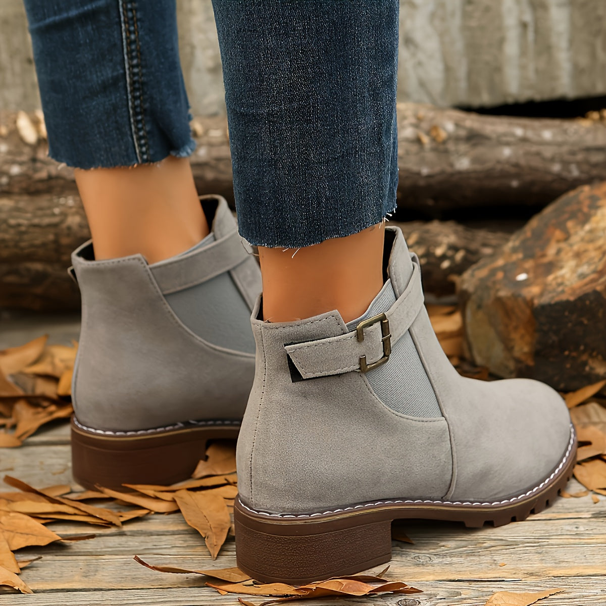 Gray vegan suede Chelsea boots for women worn with cropped jeans, showing the buckle strap and heel