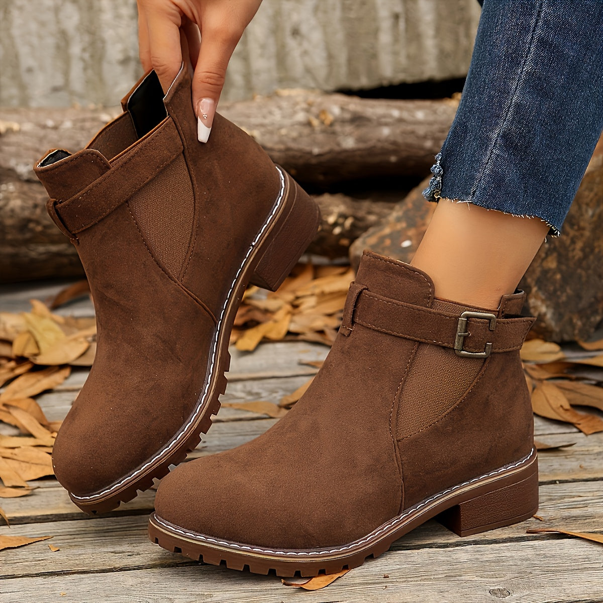 Brown vegan suede Chelsea ankle boots for women worn with cropped jeans on a wooden deck