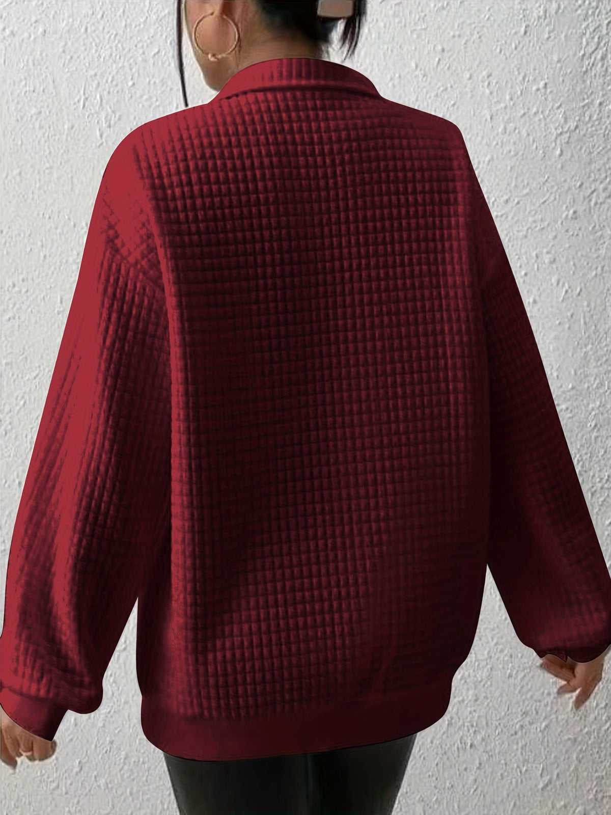 Burgundy waffle knit quarter-zip sweater close-up showing the neckline, zipper, and textured waffle knit pattern