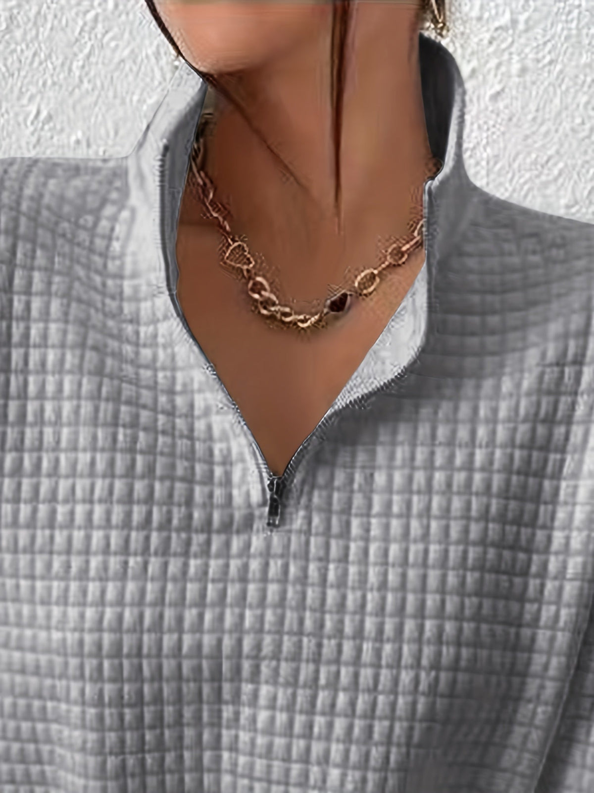 Gray waffle knit quarter-zip sweater close-up showing the neckline, zipper, and textured waffle knit pattern