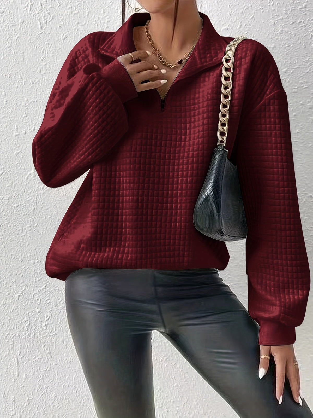 Burgundy waffle knit quarter-zip sweater worn by a female model with long sleeves and textured waffle knit fabric