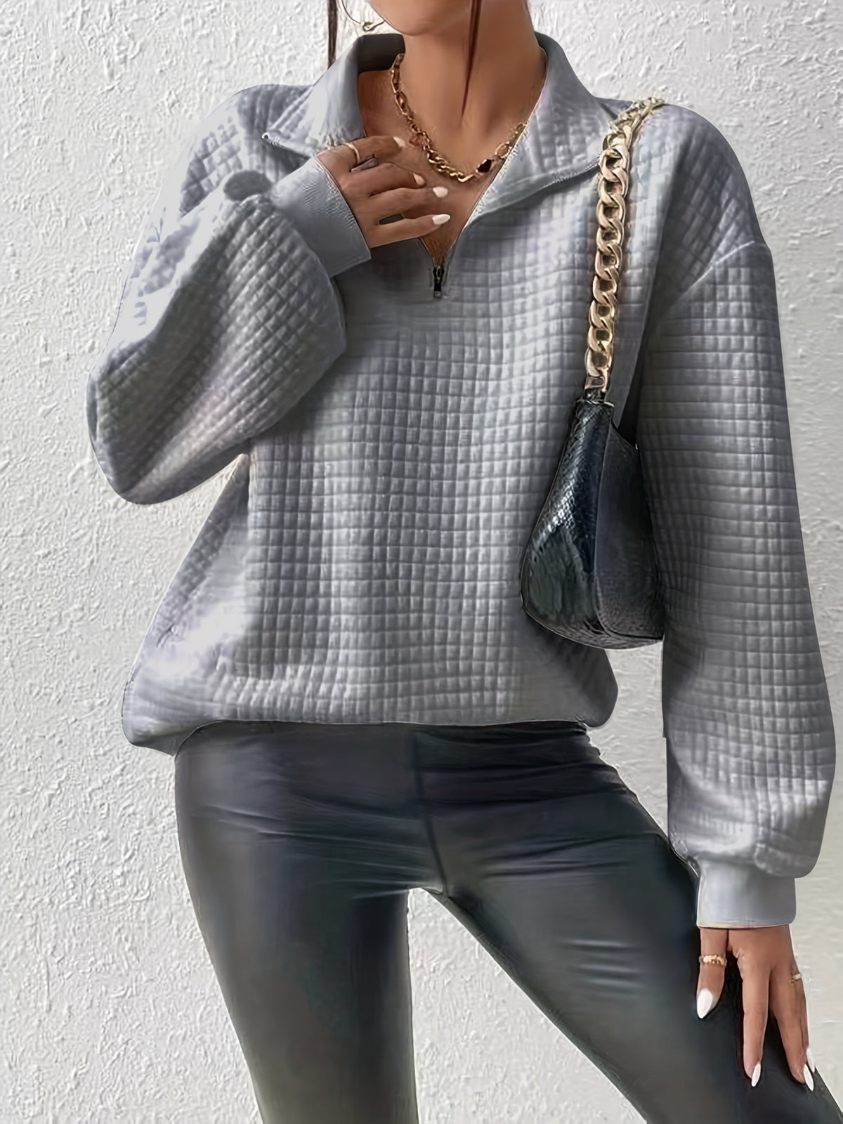 Gray waffle knit quarter-zip sweater worn by a female model, front view