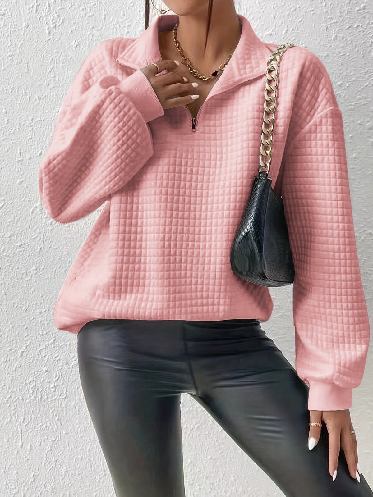 Pink waffle knit quarter-zip sweater worn by a female model with a shoulder bag