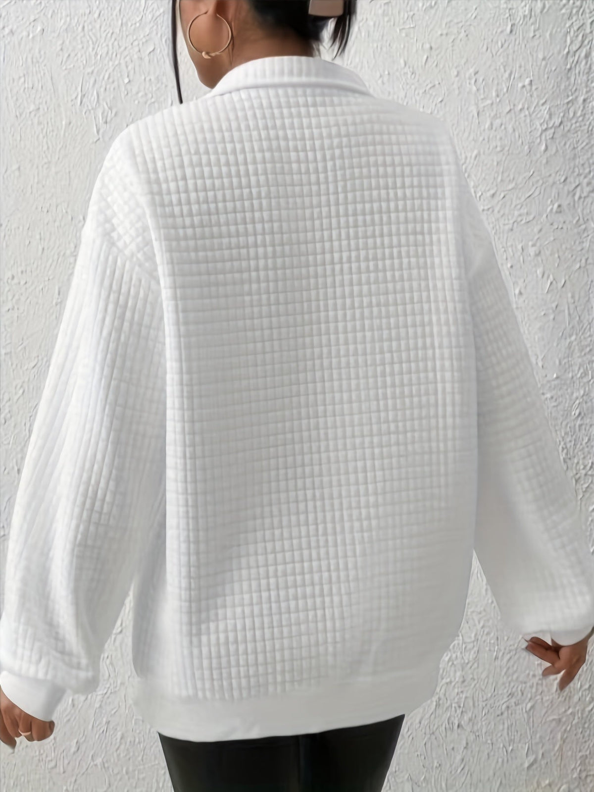 White waffle knit quarter-zip sweater shown from the back, featuring long sleeves and textured waffle knit fabric