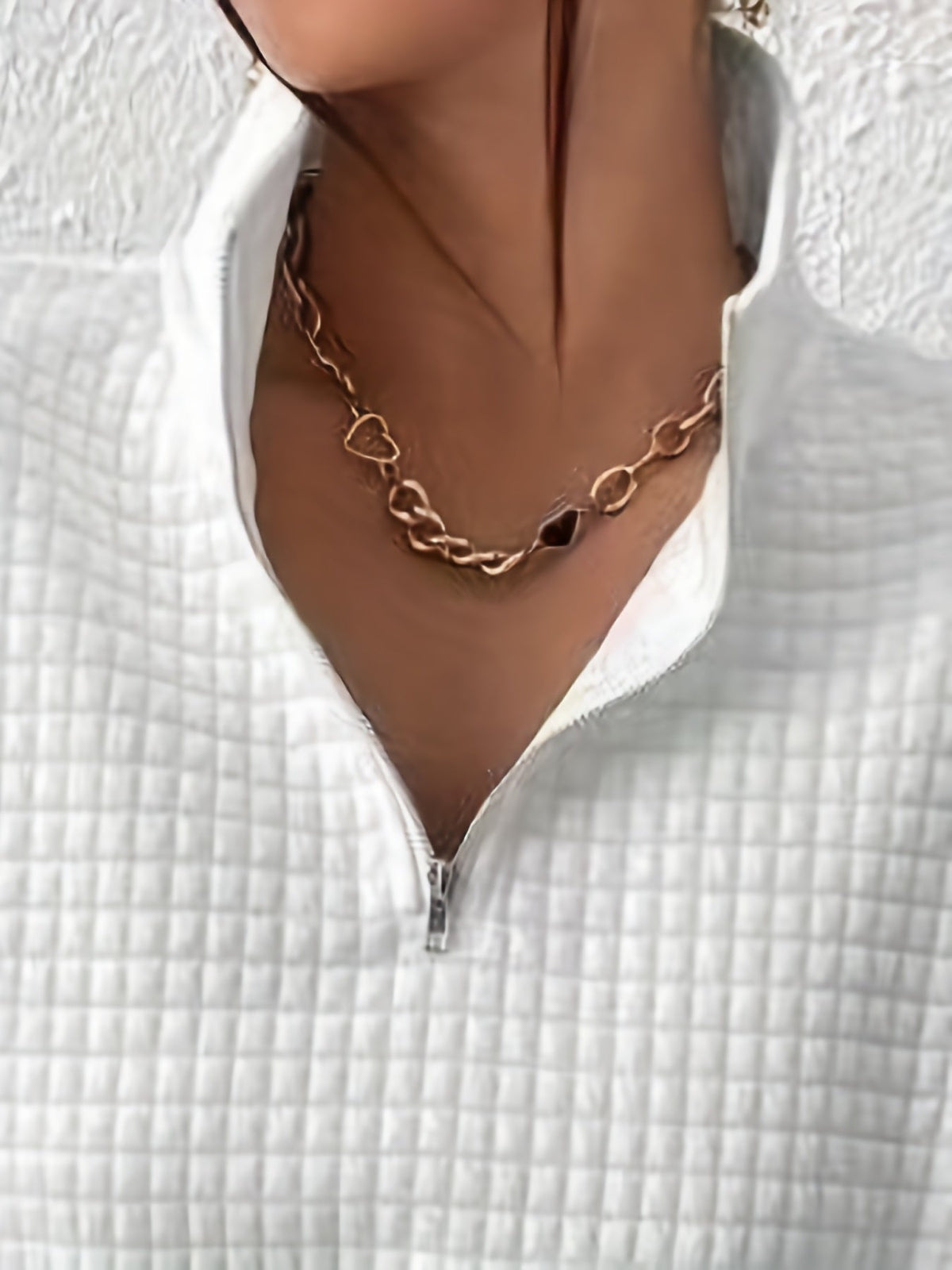 White waffle knit quarter-zip sweater close-up showing the neckline, zipper, and textured waffle knit pattern