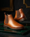 Light brown water-repellent leather Chelsea boots for men with elastic side panels and pull tab, on green marble