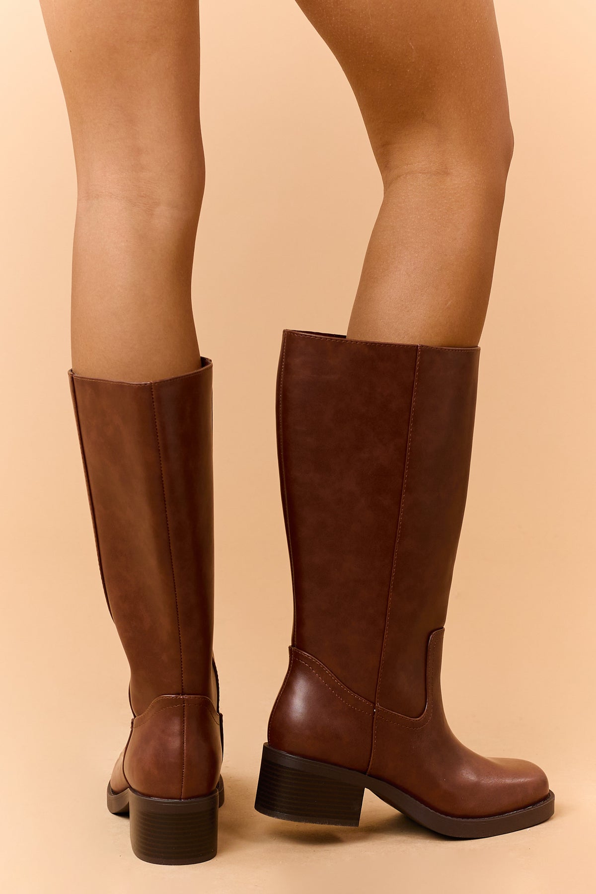 Back view of brown knee-high boots showing the full shaft and heels.