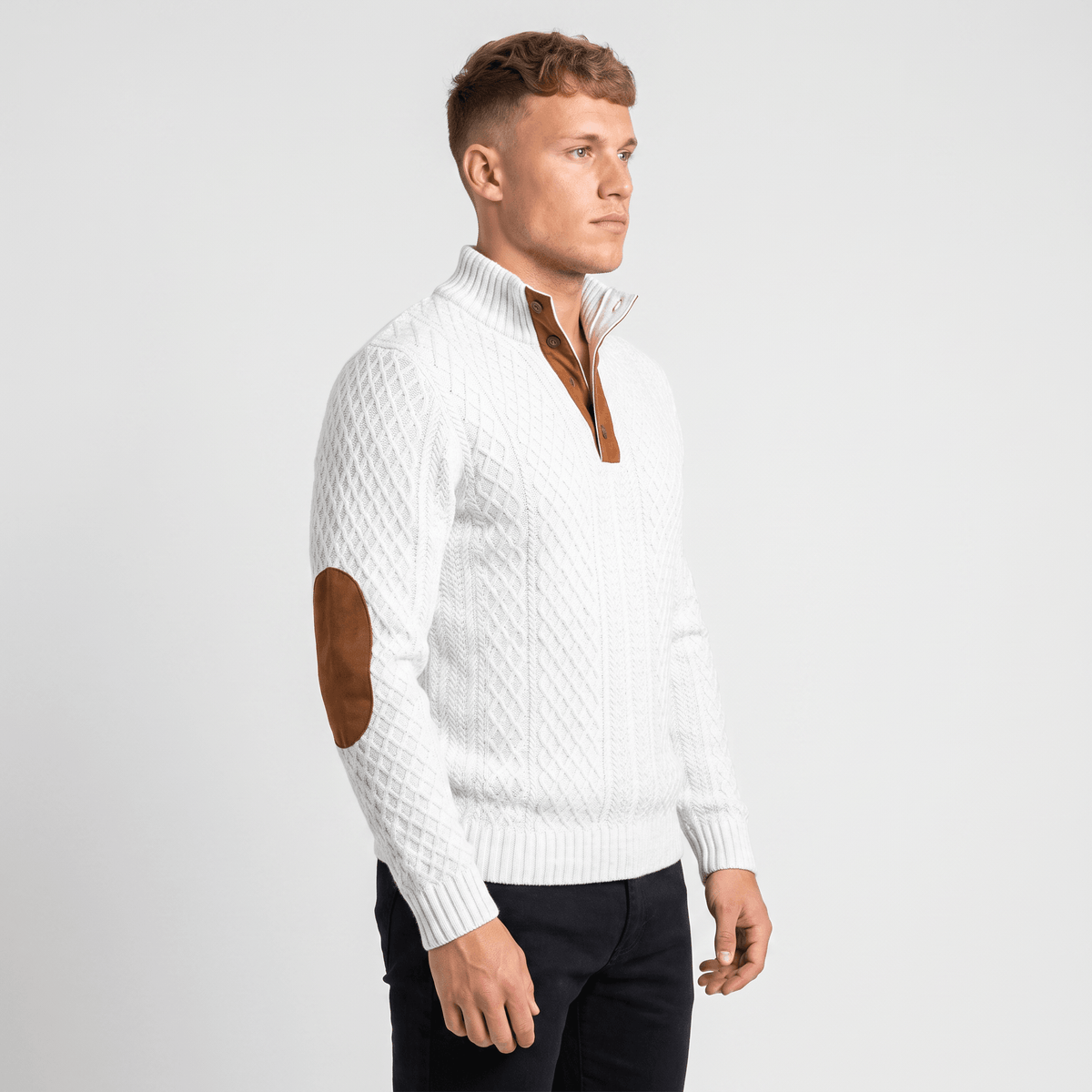 Side view of a man wearing a white cable knit Henley sweater featuring a textured knit pattern and elbow patch details.