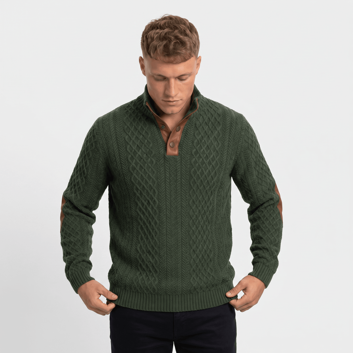 Man wearing a green cable knit Henley sweater with a stand collar, button placket, faux suede elbow patches, and a tailored fit.