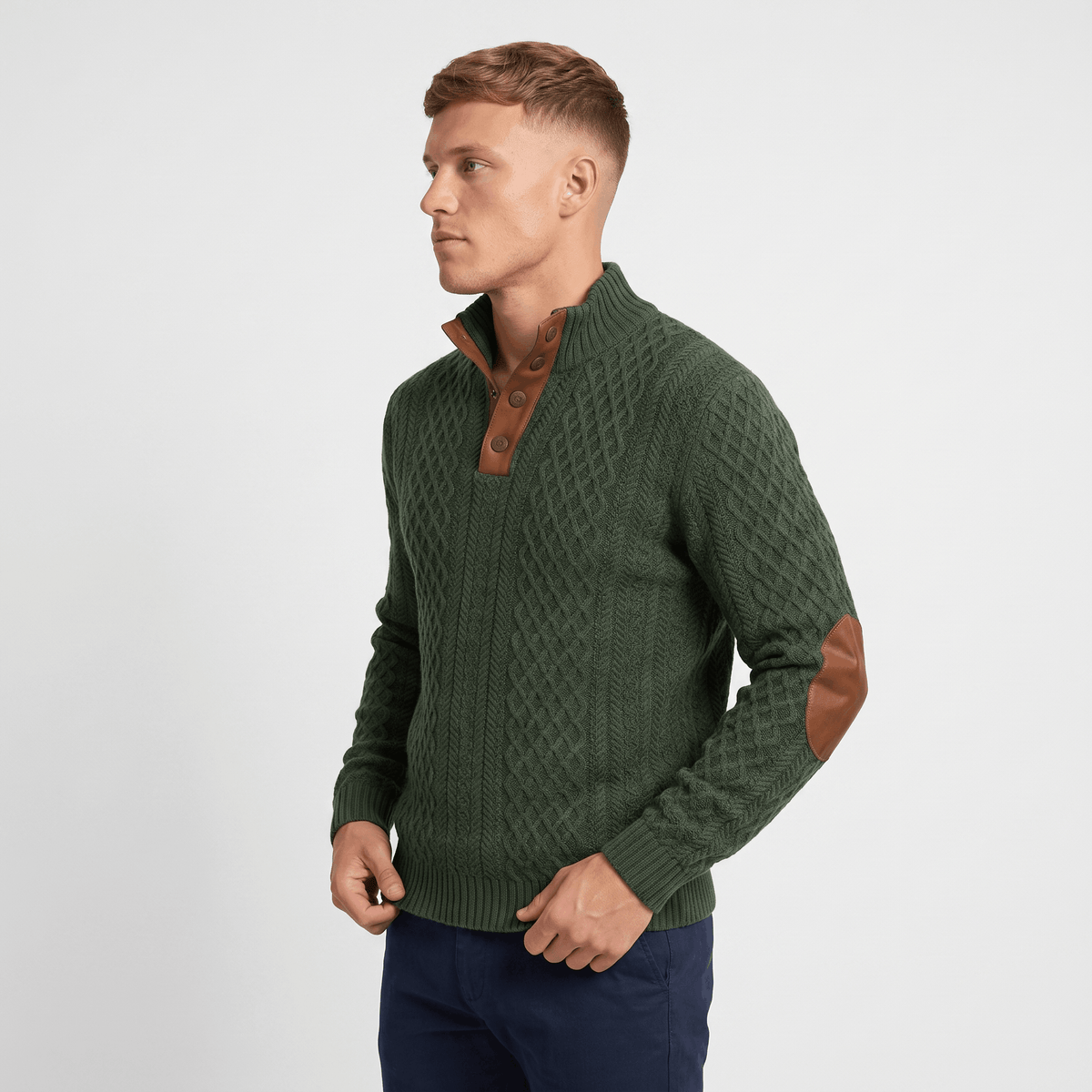 Side view of a man wearing a green cable knit Henley sweater with a textured knit pattern and elbow patches.