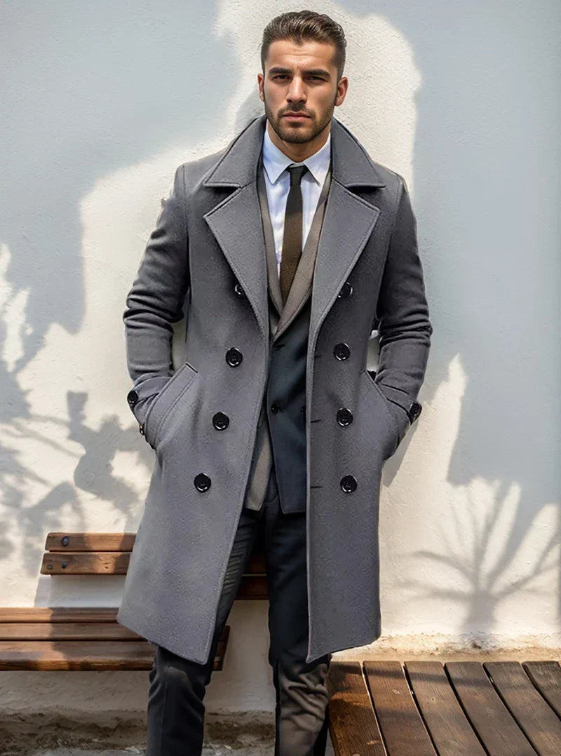 A man wearing a gray wool blend double-breasted trench coat with a tailored fit and wide lapel