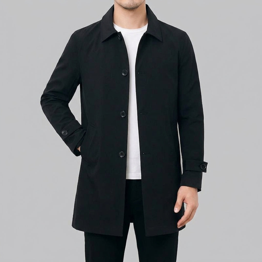A man wearing a black wool blend mid-length trench coat with a tailored fit and weatherproof finish